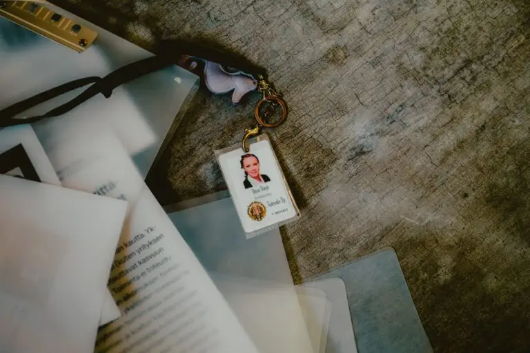 Lattialle pudonnut nippu papereita ja kansioita. Päällä HR-johtajan kulkukortti.